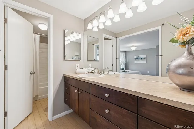 a spacious bathroom with a granite countertop sink a mirror and a shower