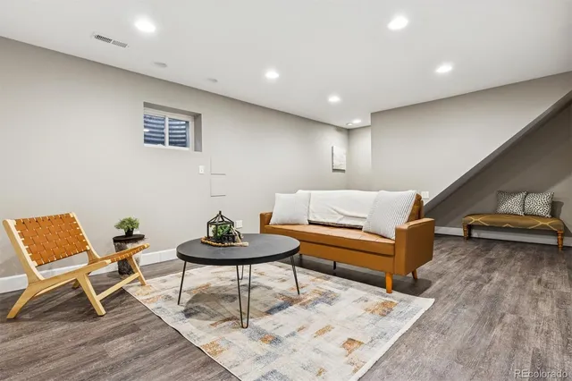 a living room with furniture and a wooden floor