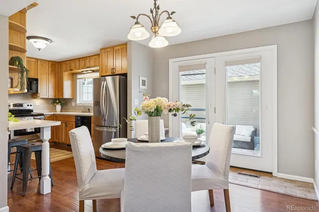 a dining room with furniture potted plants and wooden floor