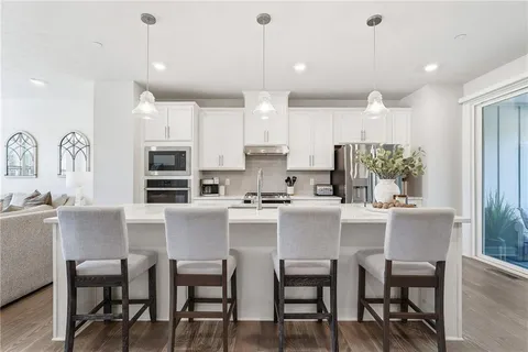 a kitchen with kitchen island a dining table and chairs