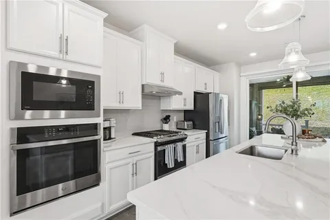 a kitchen with stainless steel appliances a stove microwave and refrigerator