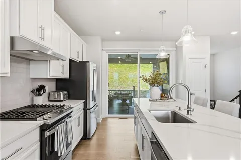 a kitchen with kitchen island a sink stove and refrigerator