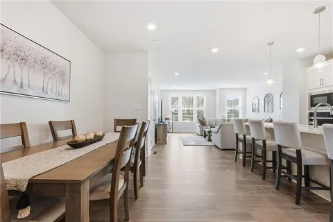 a view of a dining room and livingroom with furniture wooden floor a rug and a painting