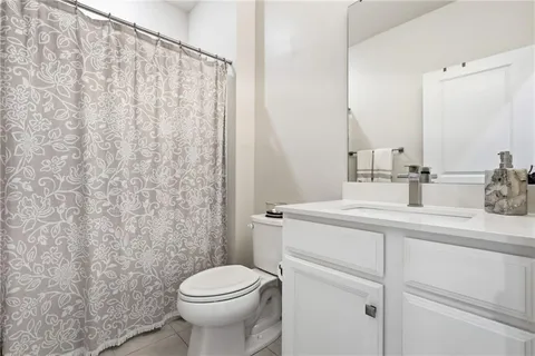 a bathroom with a sink a toilet and shower curtain