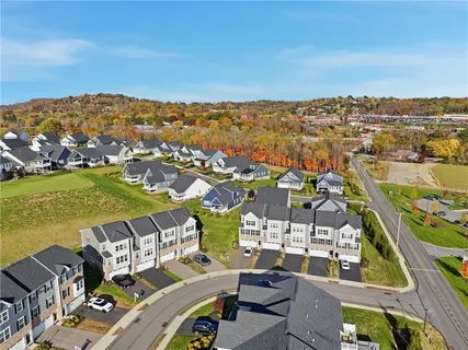 an aerial view of residential houses with outdoor space and ocean view