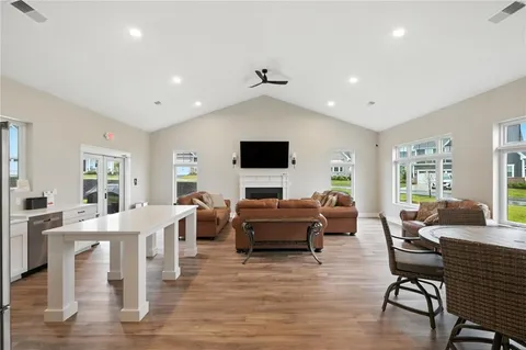 a living room with furniture flat screen tv and wooden floor