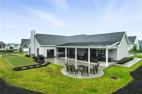 a view of a house with backyard sitting area and swimming pool