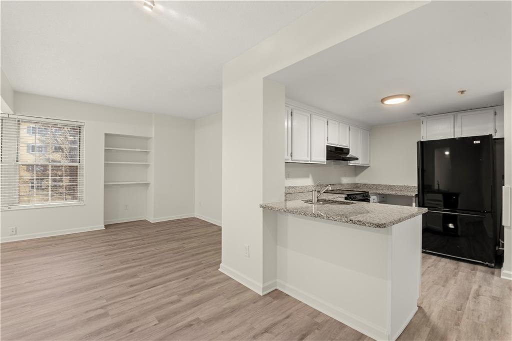 199 14th Street Northeast, Unit 201 Atlanta, GA 30309 - Photo 11 of 42 a kitchen with stainless steel appliances granite countertop a stove top oven a refrigerator a sink and dishwasher with wooden floor