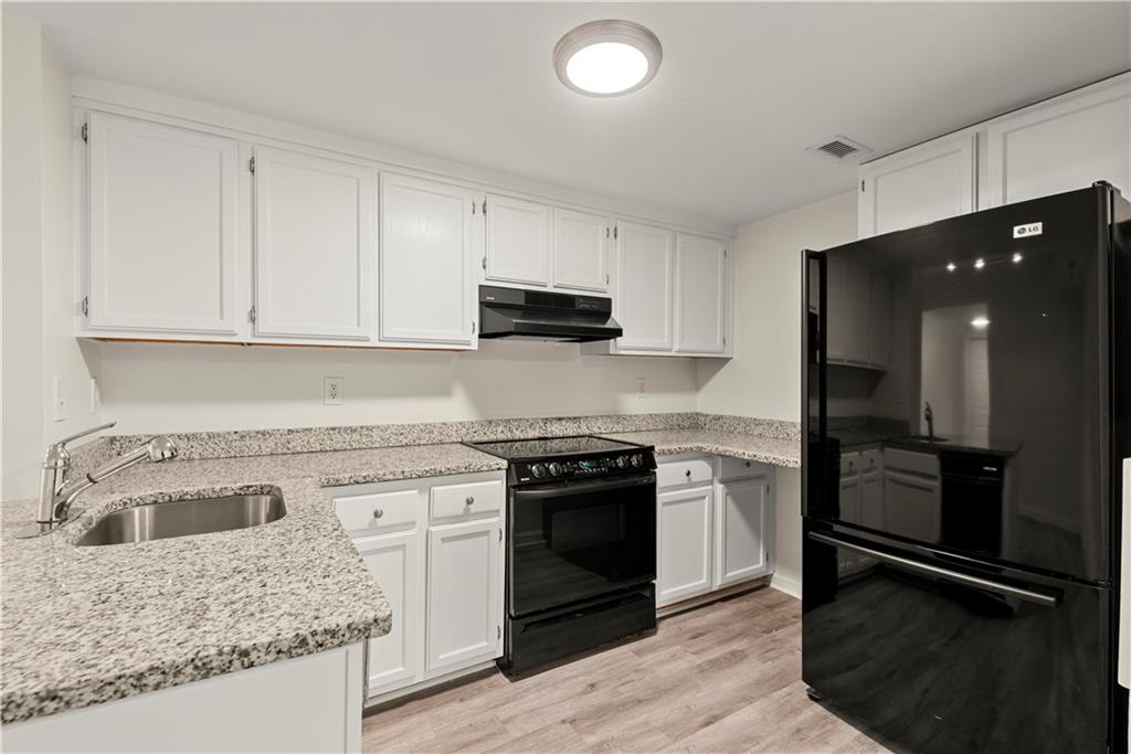 199 14th Street Northeast, Unit 201 Atlanta, GA 30309 - Photo 4 of 42 a kitchen with granite countertop a stove sink and refrigerator