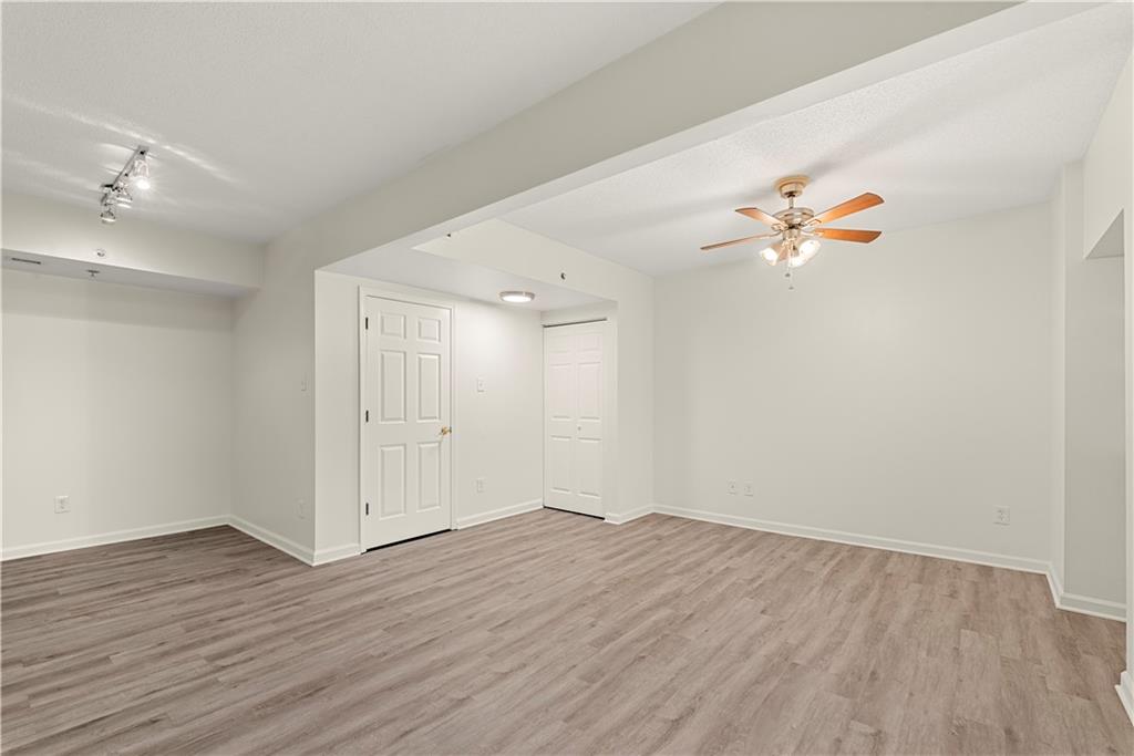 199 14th Street Northeast, Unit 201 Atlanta, GA 30309 - Photo 8 of 42 an empty room with wooden floor and fan