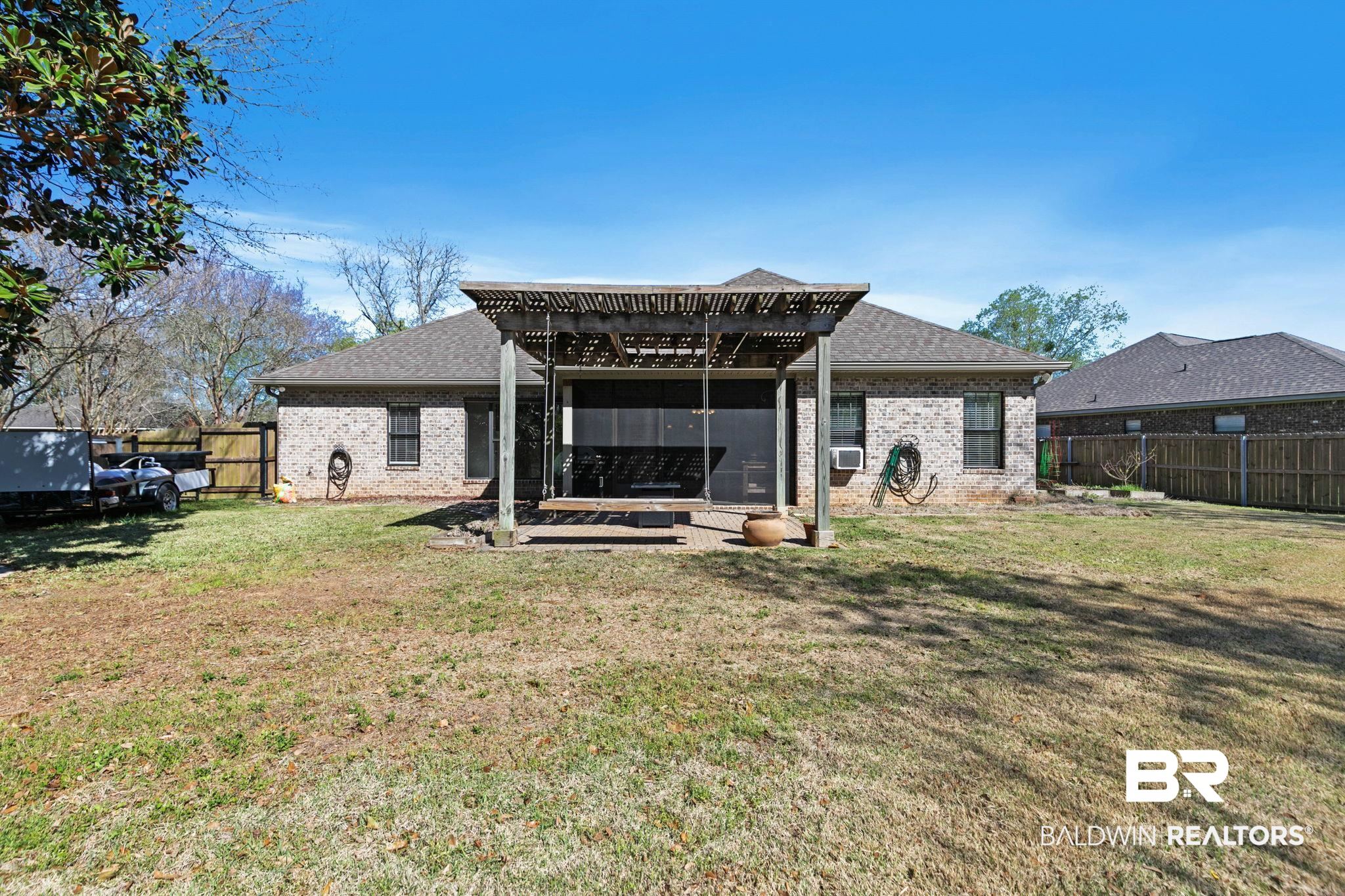 9584 Sanibel Loop Daphne, AL 36526 - Photo 39 of 48 Rear view of house featuring brick siding, a pergola, a shingled roof, and a fenced backyard