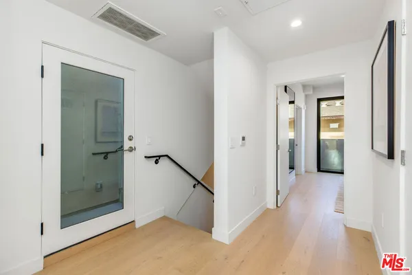 a view of a hallway with wooden floor