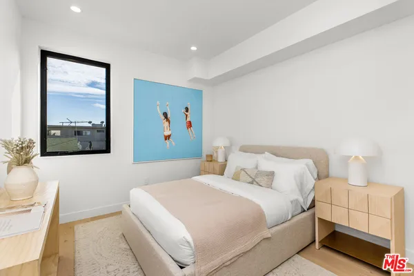 a bedroom with a bed and a painting on the wall