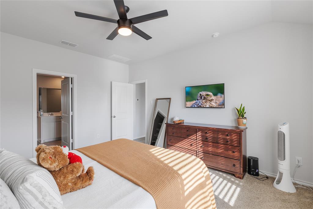 613 Whitecomb Lane Justin, TX 76247 - Photo 18 of 29 a bedroom with a bed and a dresser