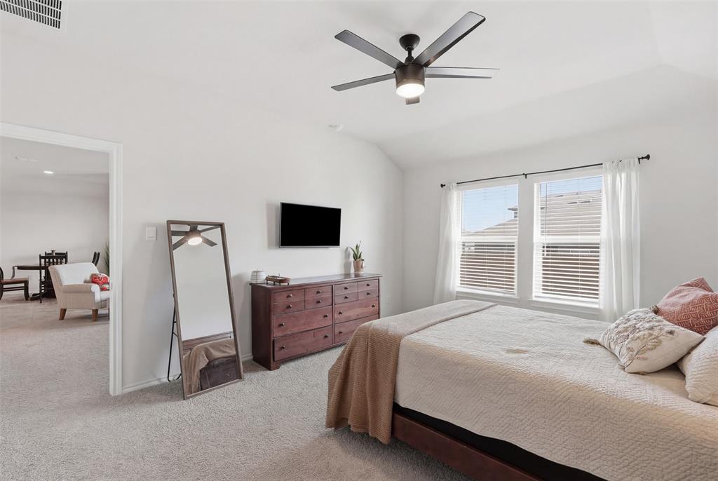 613 Whitecomb Lane Justin, TX 76247 - Photo 19 of 39 a bedroom with a bed and a flat screen tv