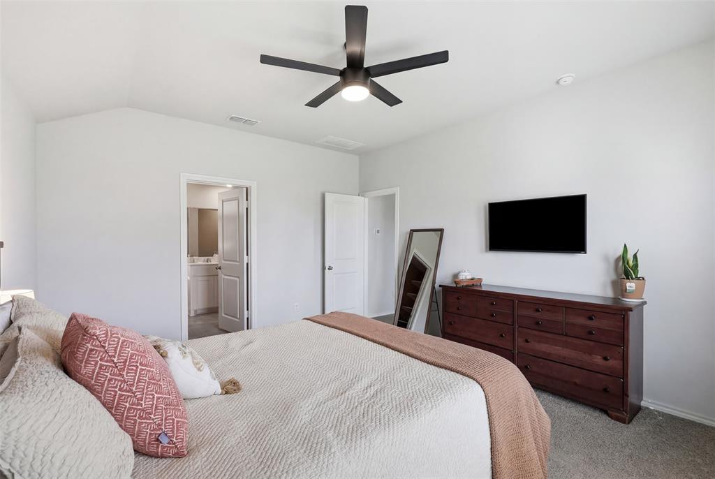 613 Whitecomb Lane Justin, TX 76247 - Photo 20 of 39 a bedroom with a bed and a flat screen tv