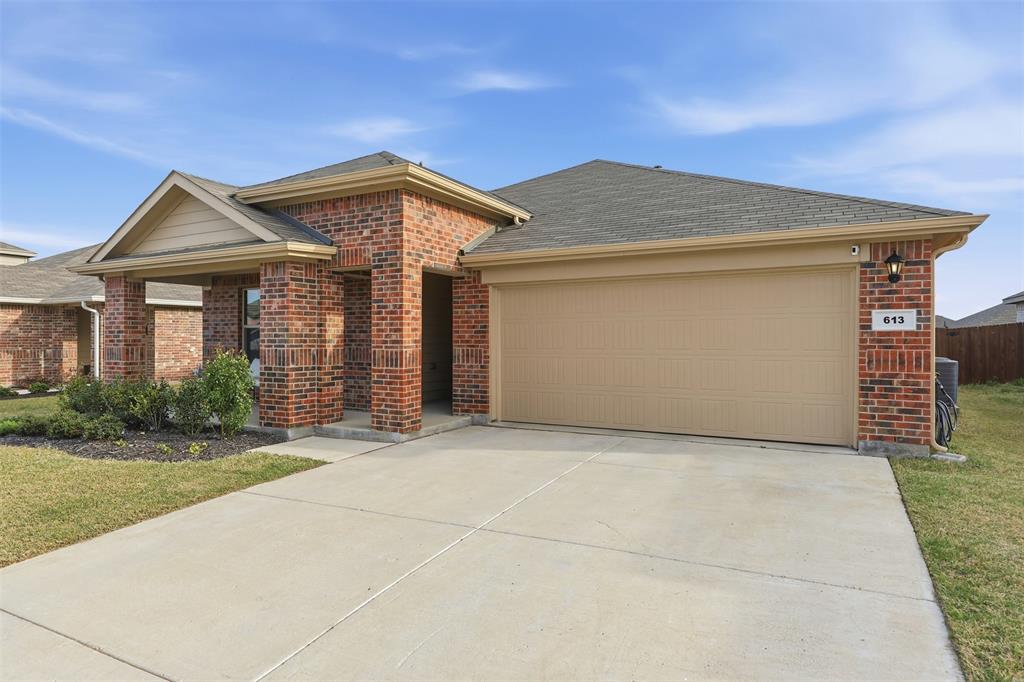 613 Whitecomb Lane Justin, TX 76247 - Photo 26 of 39 a front view of a house with a yard and garage