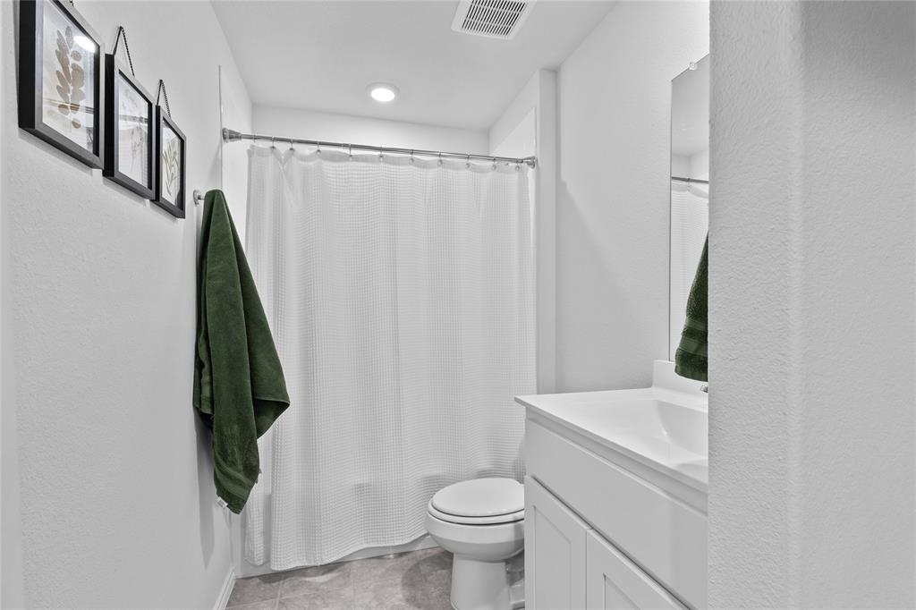 613 Whitecomb Lane Justin, TX 76247 - Photo 5 of 29 a bathroom with a shower a toilet and a sink