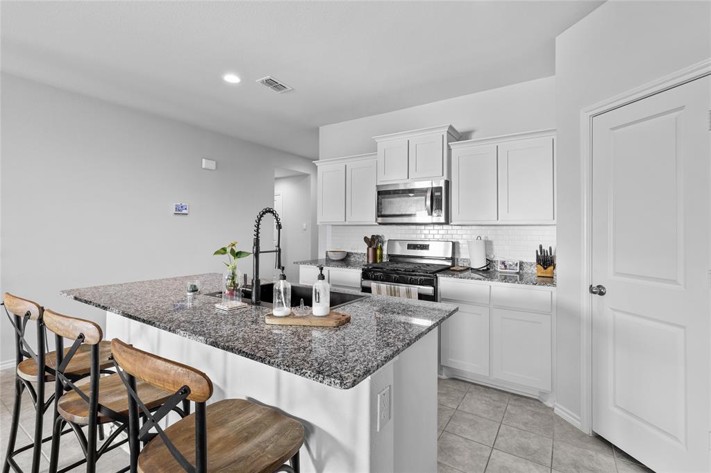 613 Whitecomb Lane Justin, TX 76247 - Photo 10 of 29 a kitchen with sink a stove and cabinets