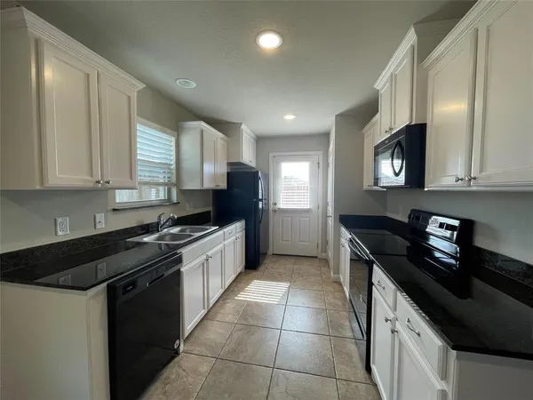 a kitchen with a sink a stove and cabinets