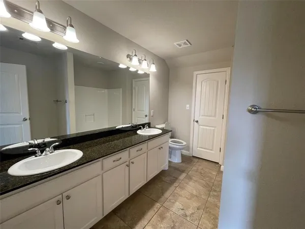 a bathroom with a double vanity sink and a mirror