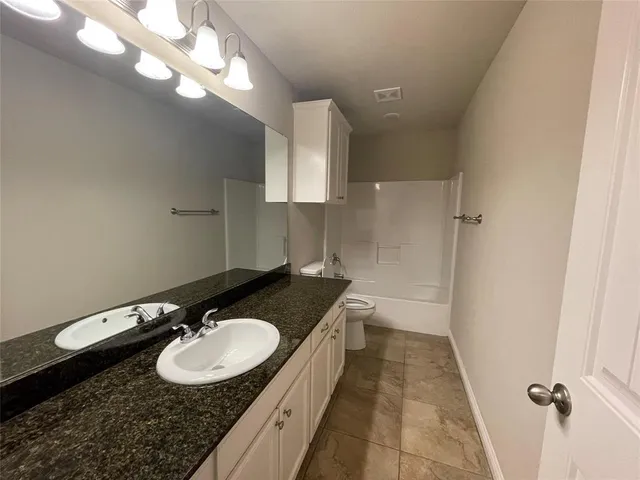 an empty room with windows and chandelier fan