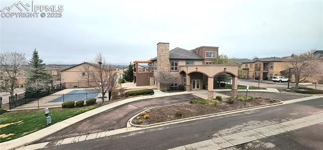 6967 Stetson Ranch Point, Unit 204 Colorado Springs, CO 80922 - Photo 12 of 13 View of front of property with a chimney, a balcony, stucco siding, and driveway