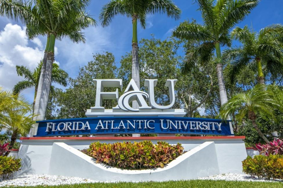 5340 Northwest 2nd Avenue, Unit PH26 Boca Raton, FL 33487 - Photo 6 of 53 a view of a sign under a palm tree