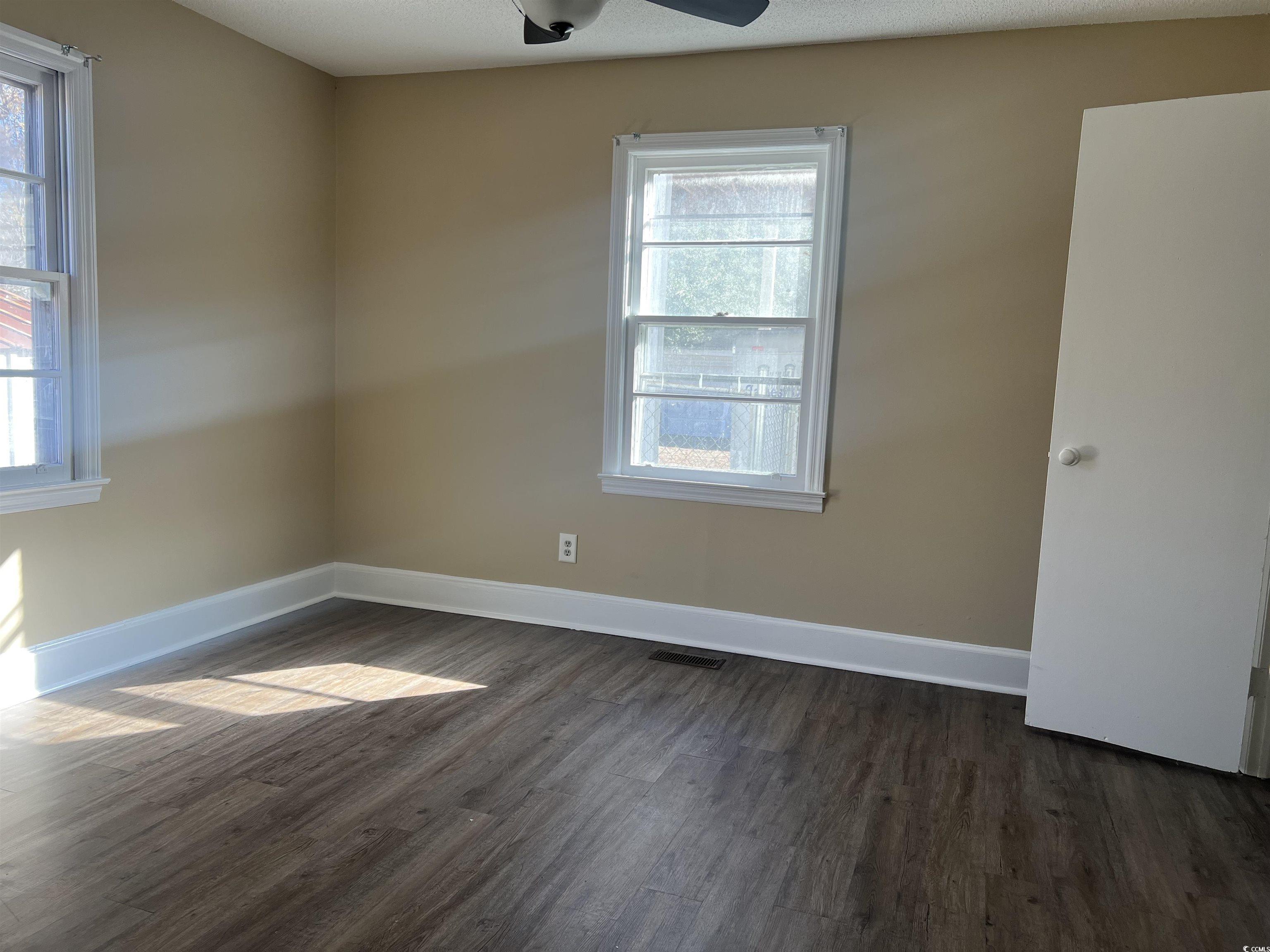 508 Sycamore Street Conway, SC 29527 - Photo 6 of 11 Empty room featuring dark wood-type flooring and a ceiling fan
