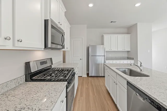 a kitchen with sink stove microwave and refrigerator