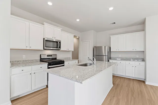 a large kitchen with stainless steel appliances a refrigerator a stove top oven and a center island