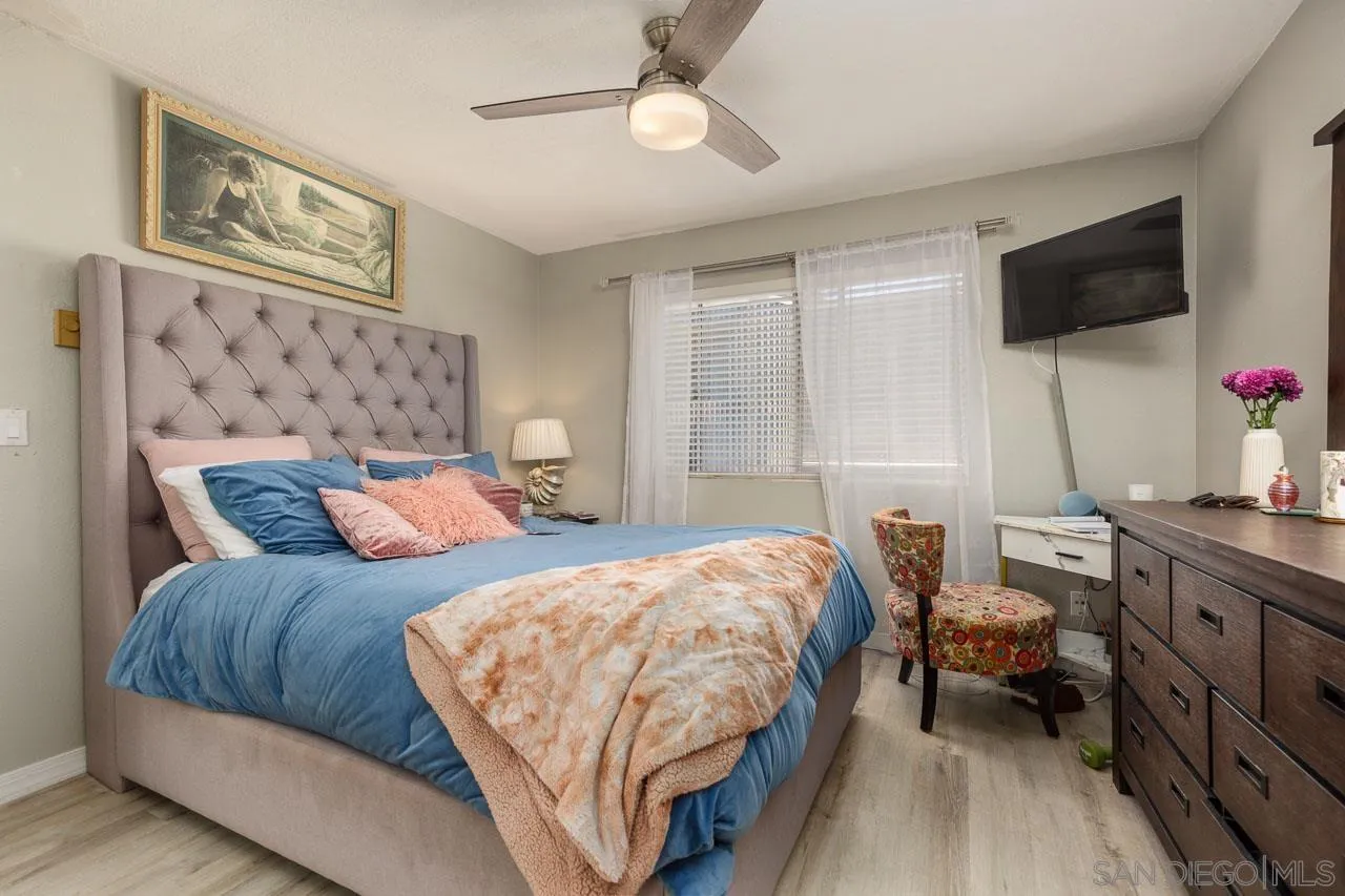 155 Rosebay Drive, Unit 28 Encinitas, CA 92024 - Photo 12 of 23 a bedroom with a bed flat screen tv and a couch