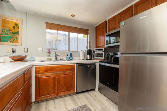 a kitchen with stainless steel appliances a refrigerator sink and cabinets
