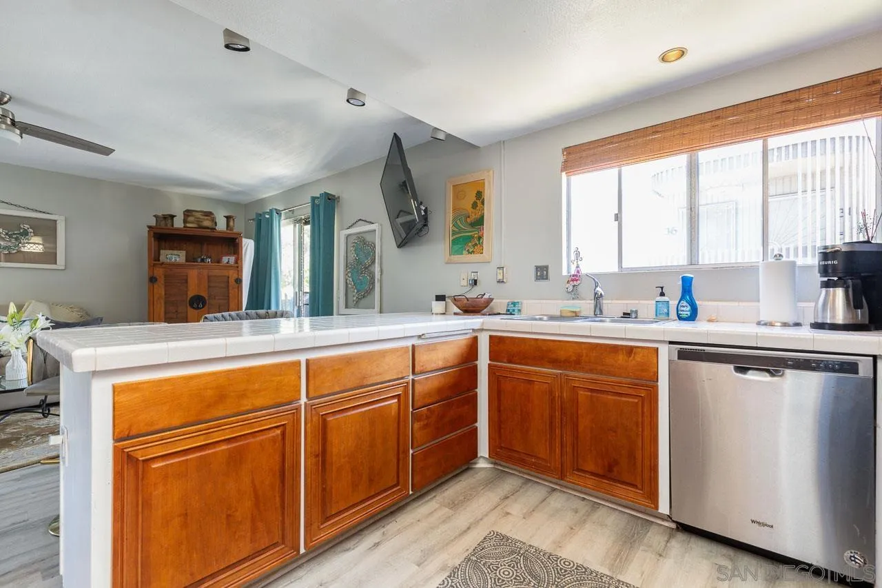 155 Rosebay Drive, Unit 28 Encinitas, CA 92024 - Photo 9 of 23 a kitchen with stainless steel appliances granite countertop wooden cabinets a sink and a large window