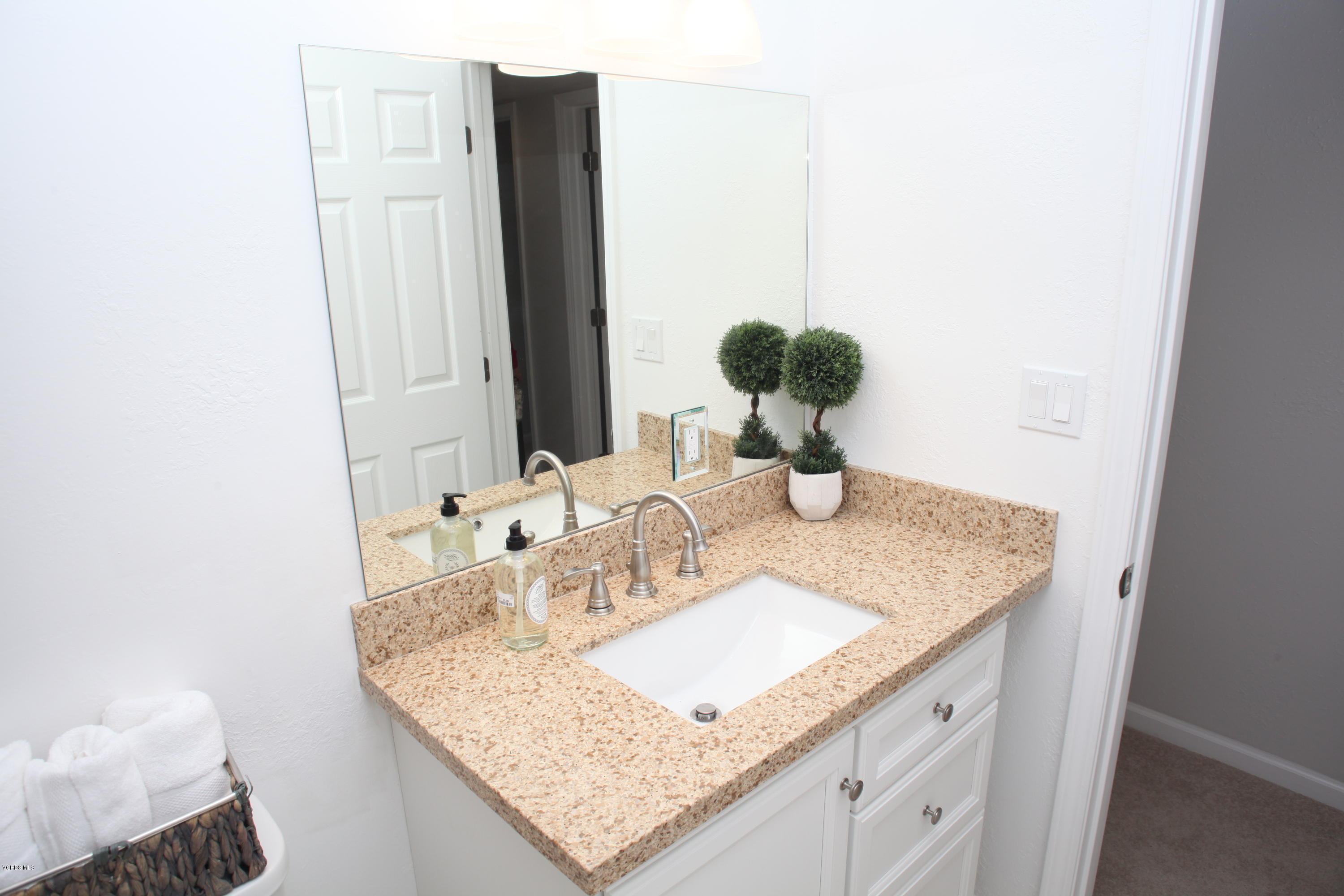 2061 Rhoda Street Simi Valley, CA 93065 - Photo 17 of 27 a bathroom with a granite countertop sink and a mirror