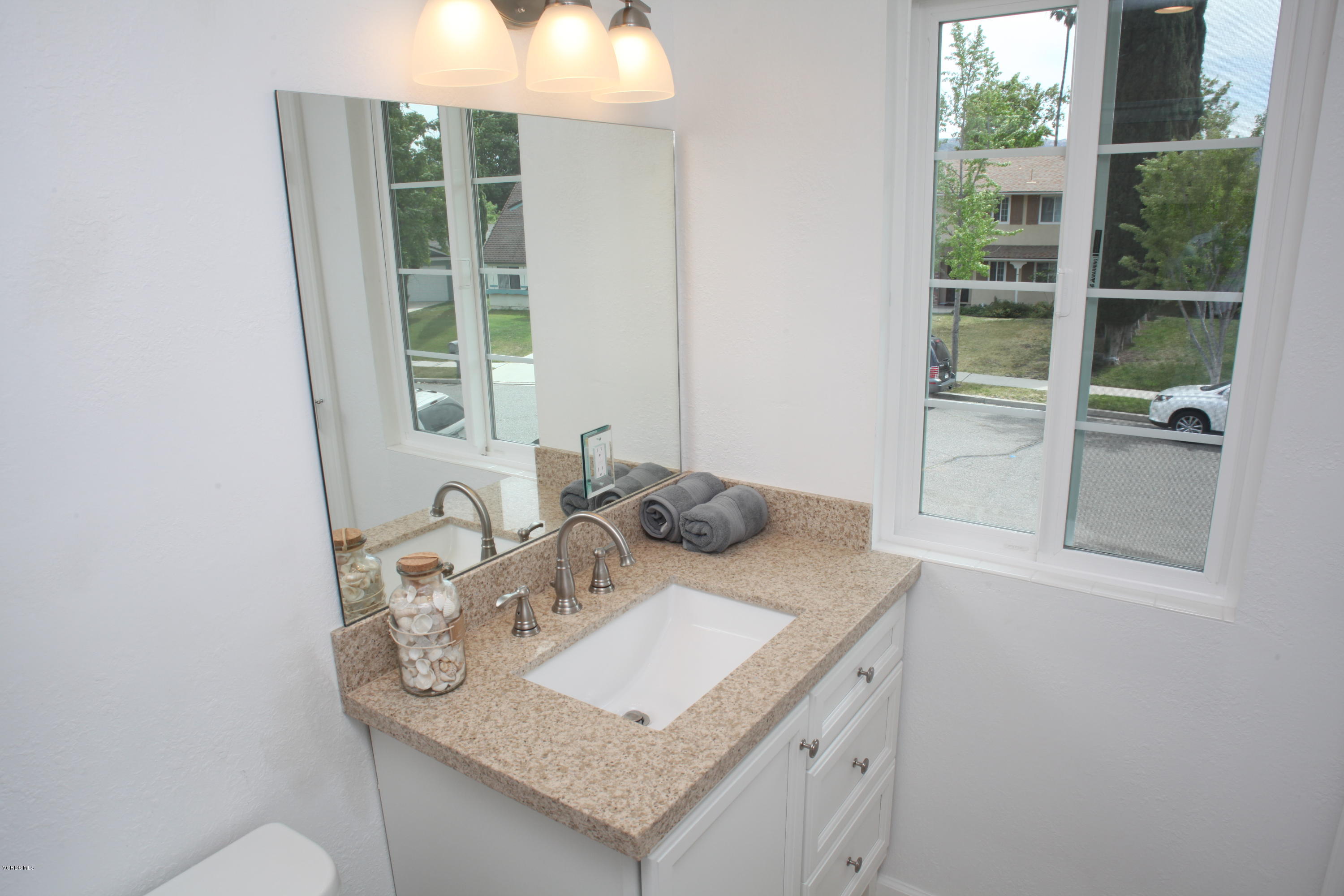 2061 Rhoda Street Simi Valley, CA 93065 - Photo 22 of 27 a bathroom with a granite countertop sink and a mirror