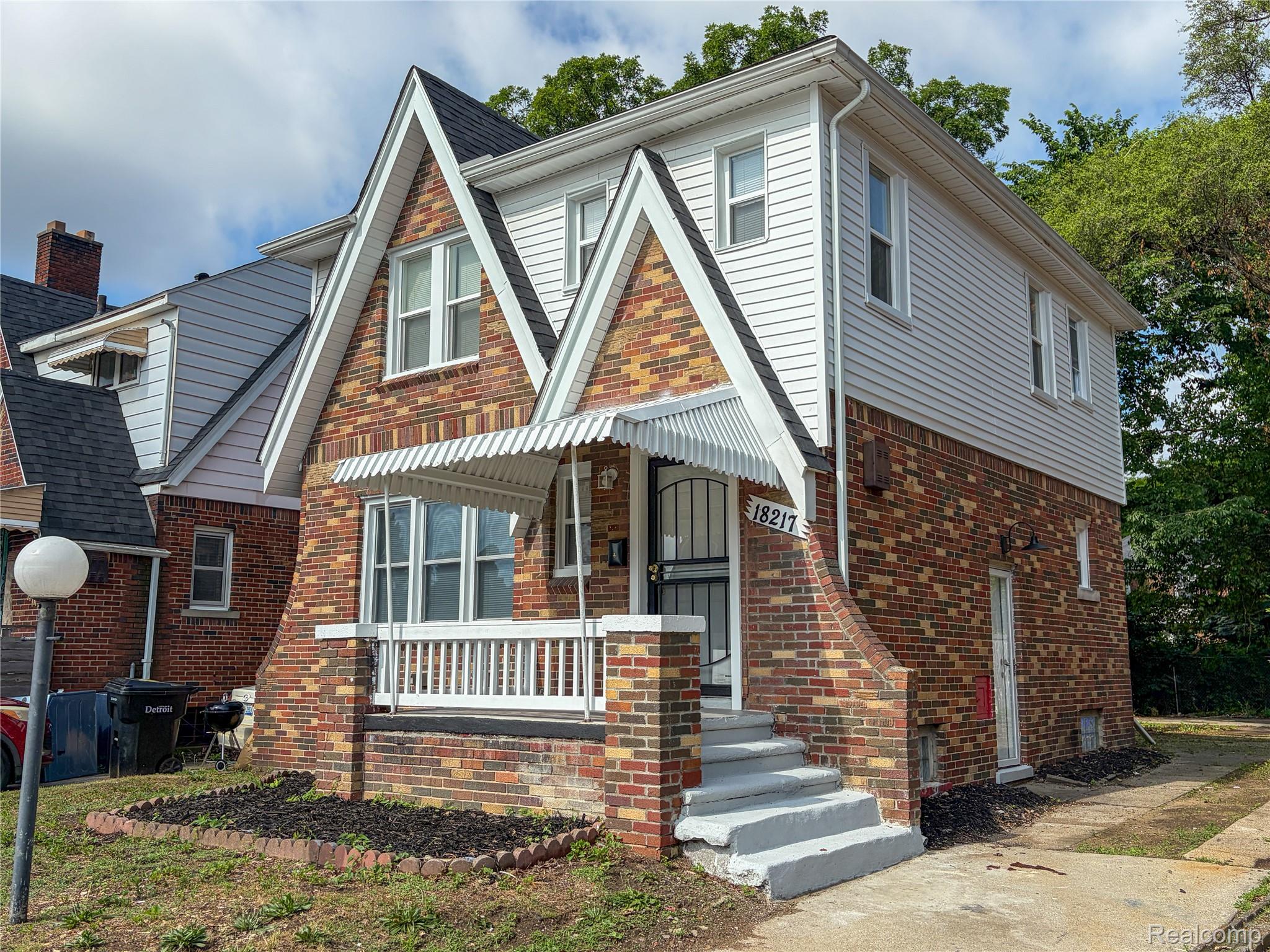 18217 Prairie Street Detroit, MI 48221 - Photo 4 of 34 Brick and siding exterior featuring a covered porch, front awning, and multiple windows