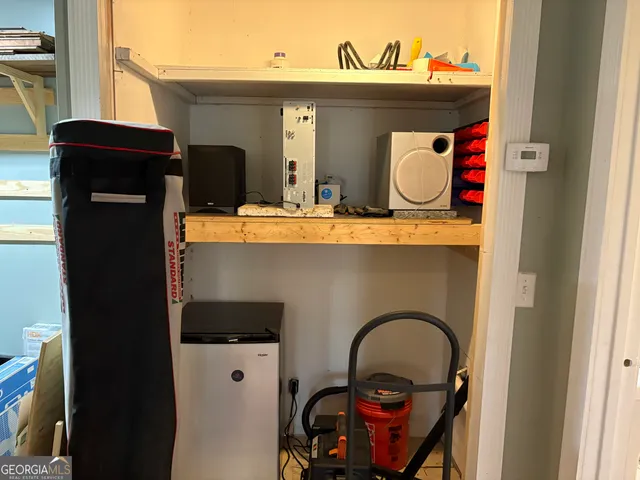 a view of an empty room and kitchen with furniture wooden floor and window