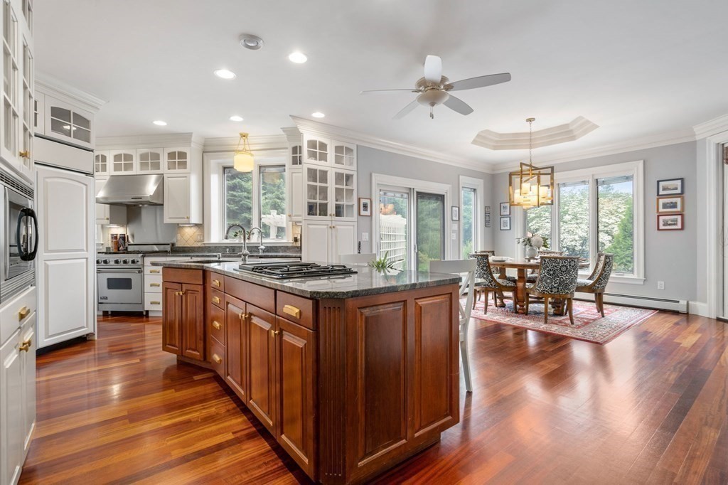 3 Nixon Road Framingham, MA 01701 - Photo 8 of 42 a kitchen with stainless steel appliances granite countertop a stove top oven a refrigerator a dining table and chairs with wooden floor