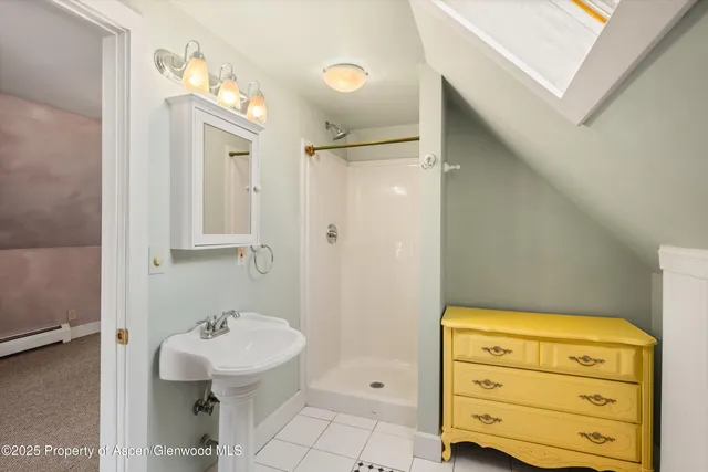 a bathroom with a sink a mirror and shower