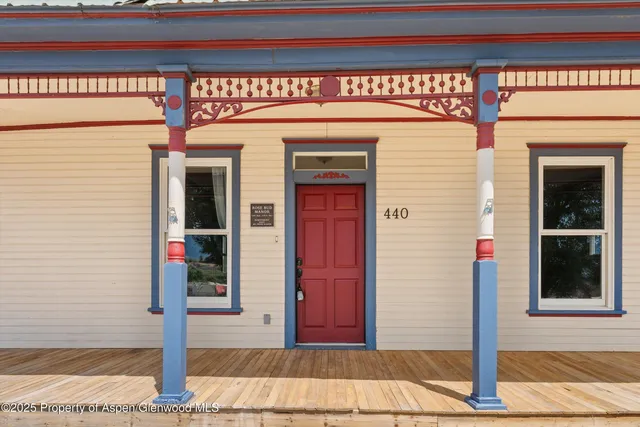 a front view of a building with red door