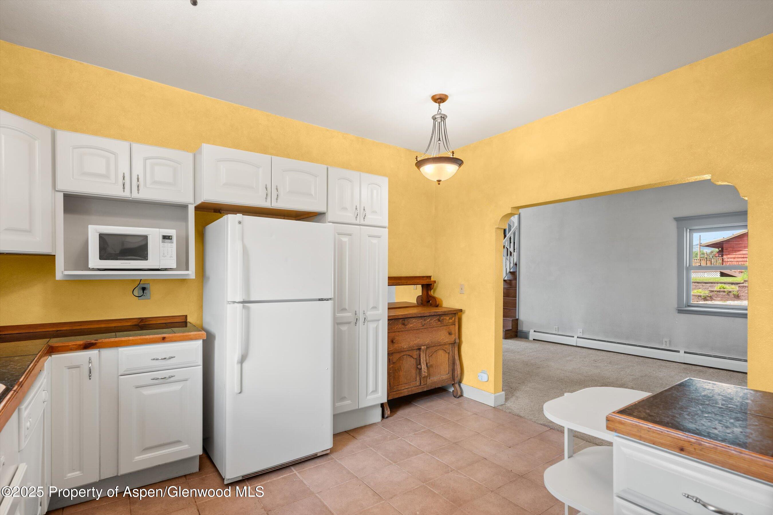 440 Whiteriver Avenue Rifle, CO 81650 - Photo 10 of 25 a kitchen with stainless steel appliances granite countertop a refrigerator a sink and white cabinets