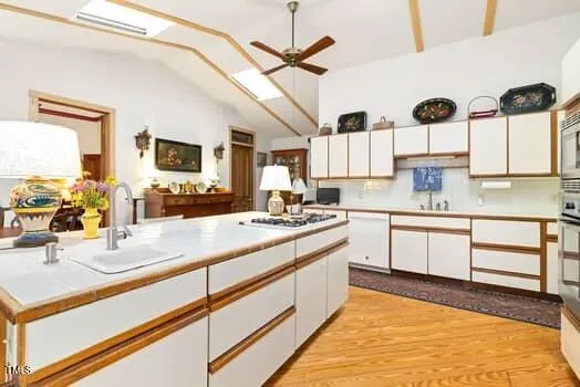 a kitchen with stainless steel appliances kitchen island granite countertop a table chairs and a refrigerator