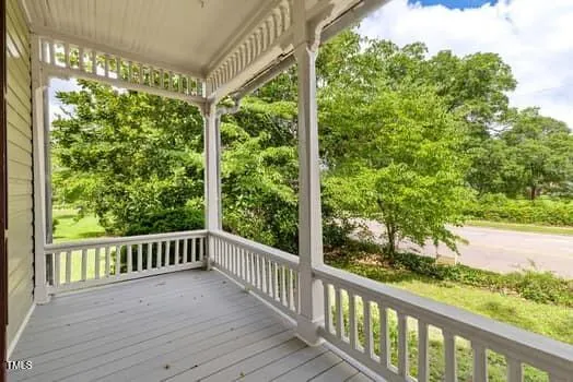a view of a house with a yard and large trees
