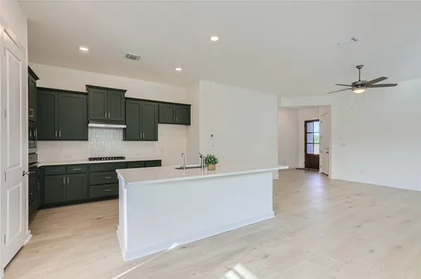 a large kitchen with stainless steel appliances granite countertop a stove a sink and a refrigerator
