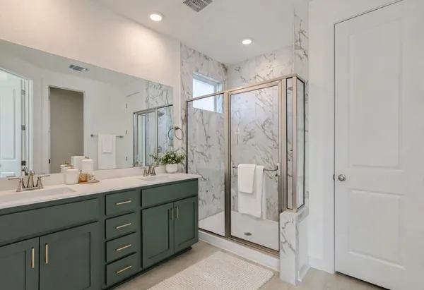 a bathroom with a double sink shower double vanity and a mirror