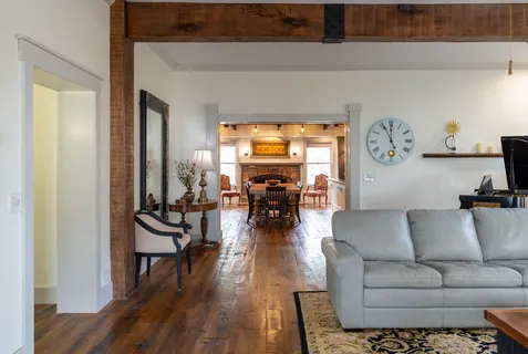 a view of a hallway with wooden floor fireplace and living room