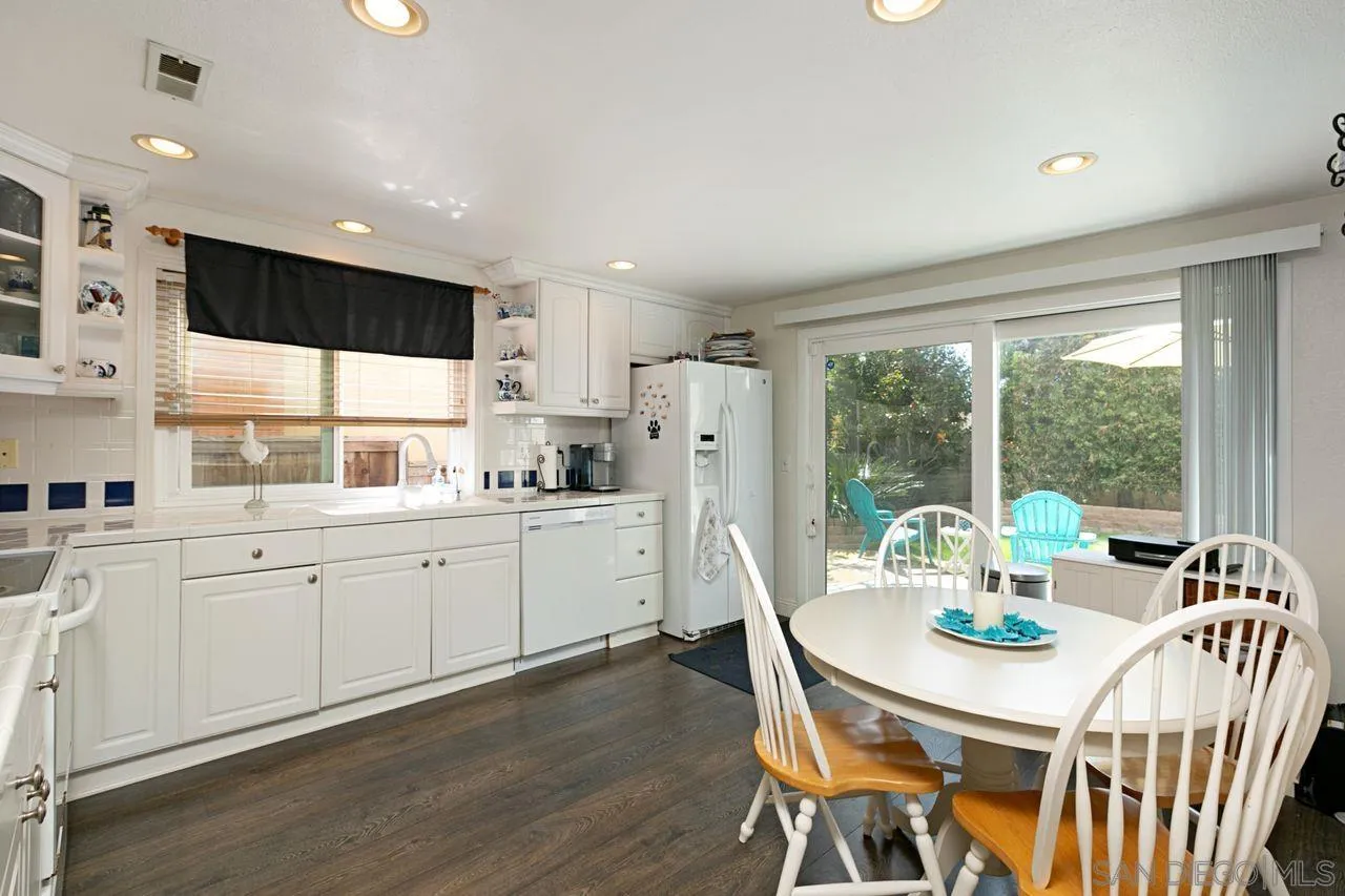 946 Alyssum Road Carlsbad, CA 92011 - Photo 6 of 19 a kitchen with stainless steel appliances granite countertop a stove a refrigerator a kitchen island with a dining table and chairs