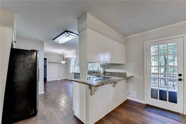 a kitchen with granite countertop white cabinets and appliances