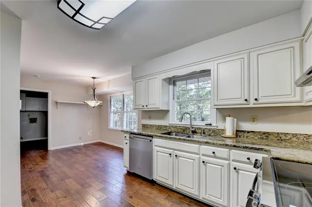 a kitchen with stainless steel appliances granite countertop a stove and white cabinets
